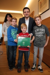 Yannick, Aurélie und Lea Powileit überreichen Bürgermeister Greiber das Erste Kids Climate Conference Buch