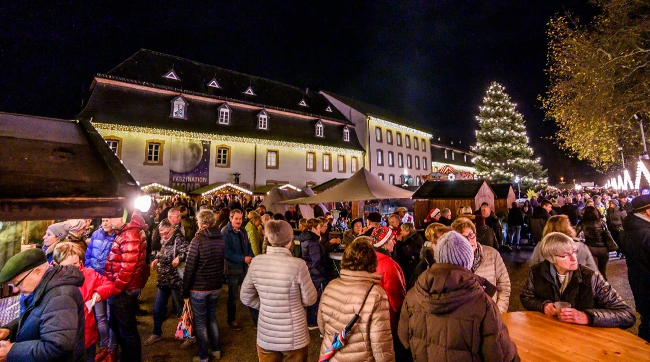 Viele Menschen besuchen am Abend den beleuchteten Wadgasser Weihnachtsmarkt.